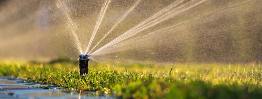 A sprinkler system running in a yard. 